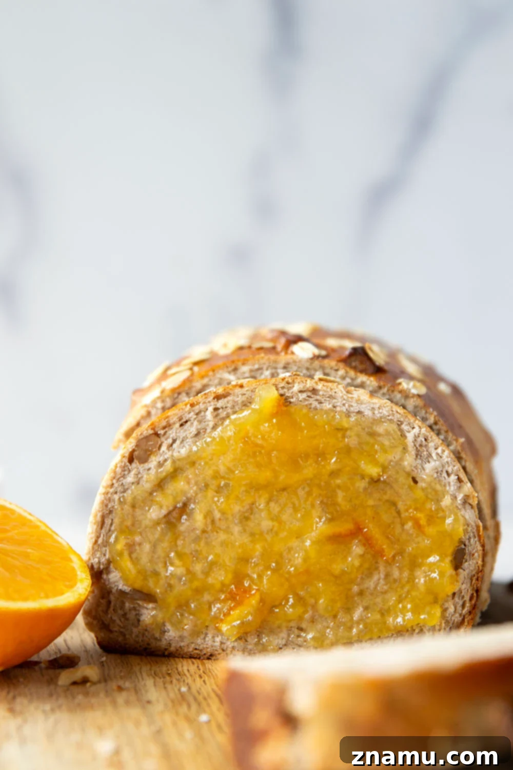 Sun-Kissed Orange Walnut Loaf 2 Freshly baked Orange Walnut Yeast Bread on a cutting board, sliced and ready to serve.