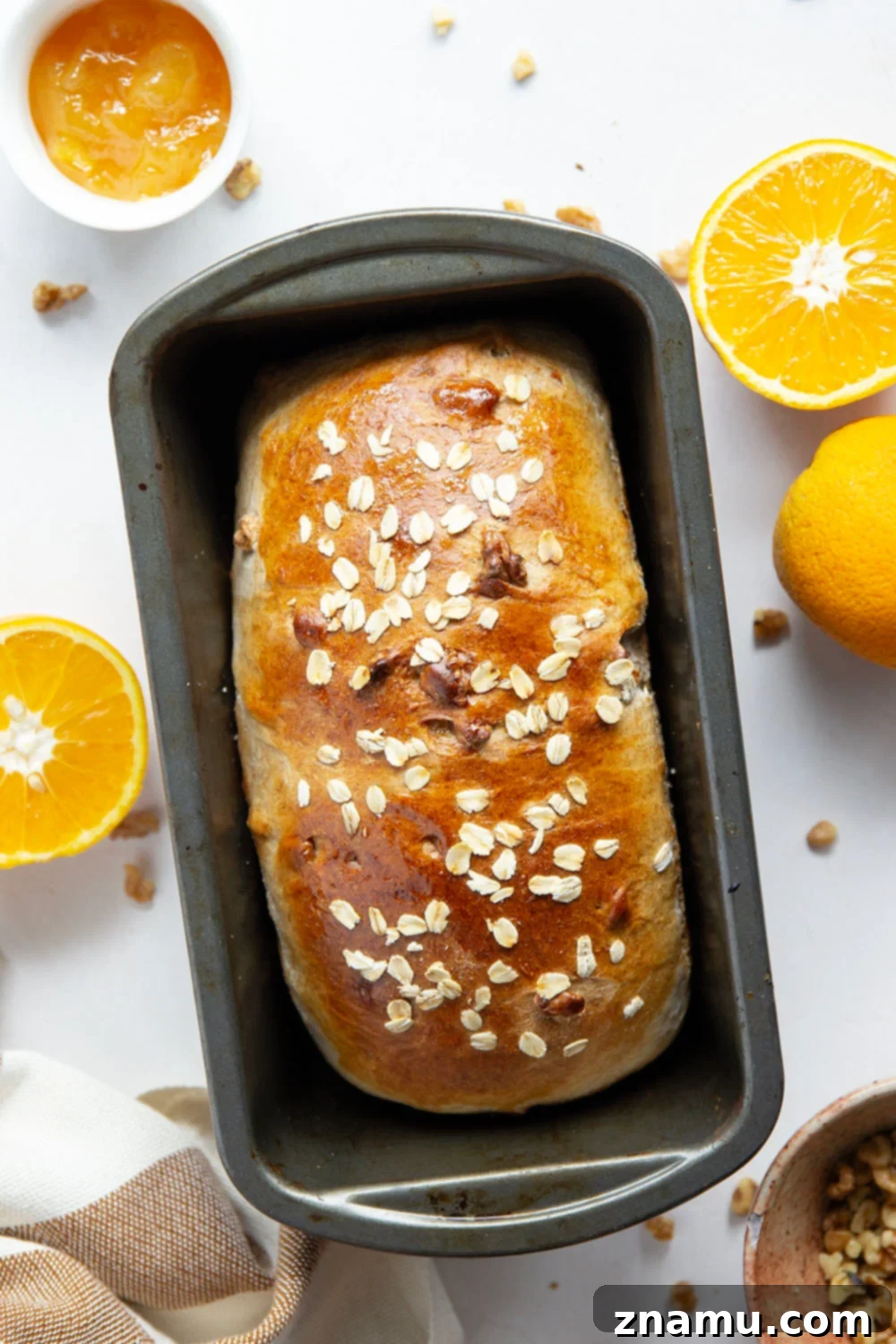 Sun-Kissed Orange Walnut Loaf 3 Close-up of a warm Orange Walnut Yeast Bread loaf, showing its golden crust and texture.
