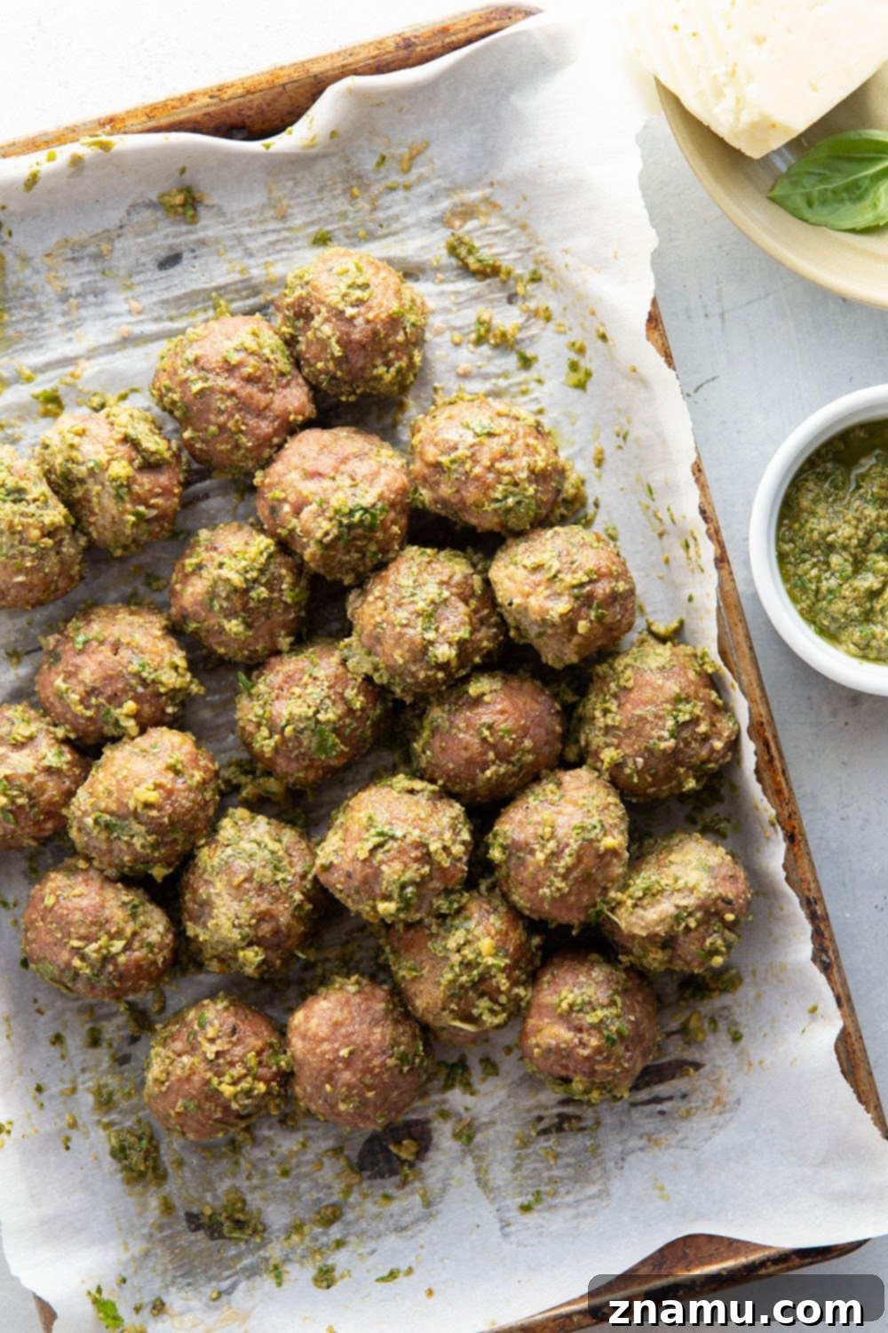 A tray of freshly baked pesto meatball sandwiches ready to be served, highlighting their golden toasted buns and rich filling.