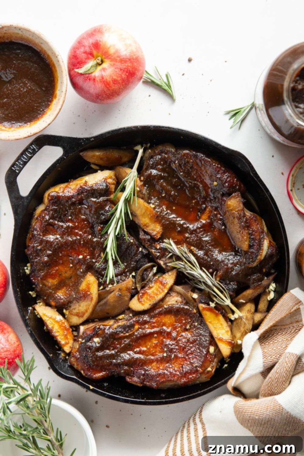 Sticky Apple Butter Pork Chops 5 A close-up view of raw thick-cut bone-in pork chops seasoned with salt and pepper, ready for searing in a skillet.