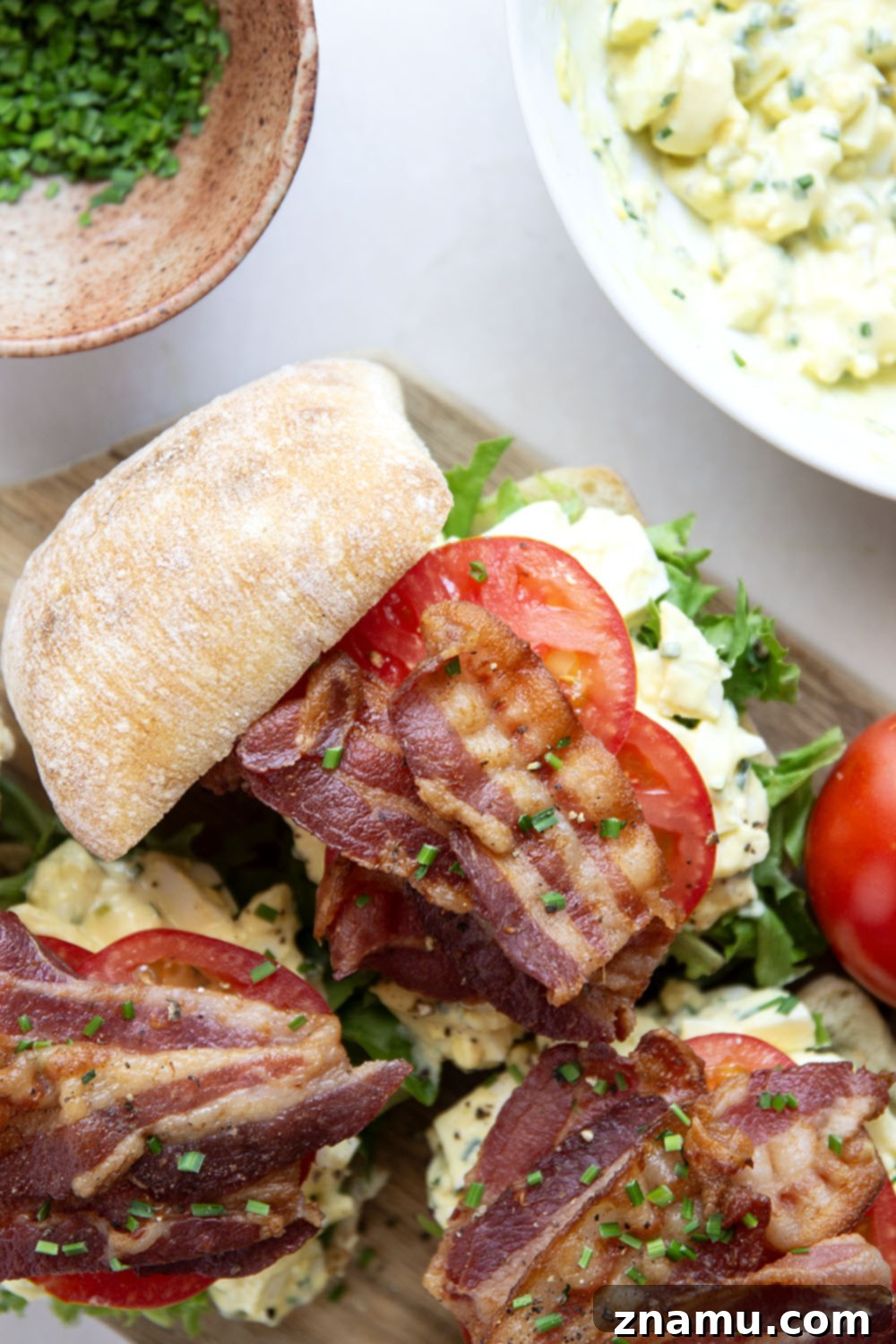 BLT Egg Salad Twist 6 Two halves of a delicious BLT Egg Salad sandwich stacked on a plate, showcasing all layers