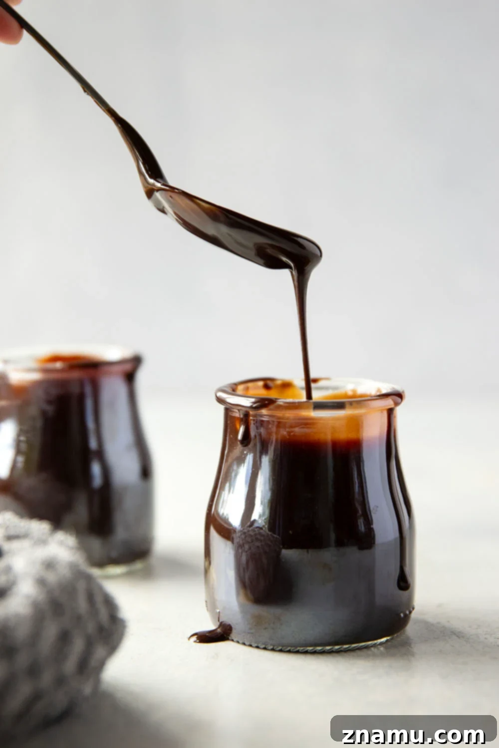 Decadent Homemade Hot Fudge Sauce 2 Luxurious homemade hot fudge sauce drizzled over ice cream, a delicious chocolate treat.