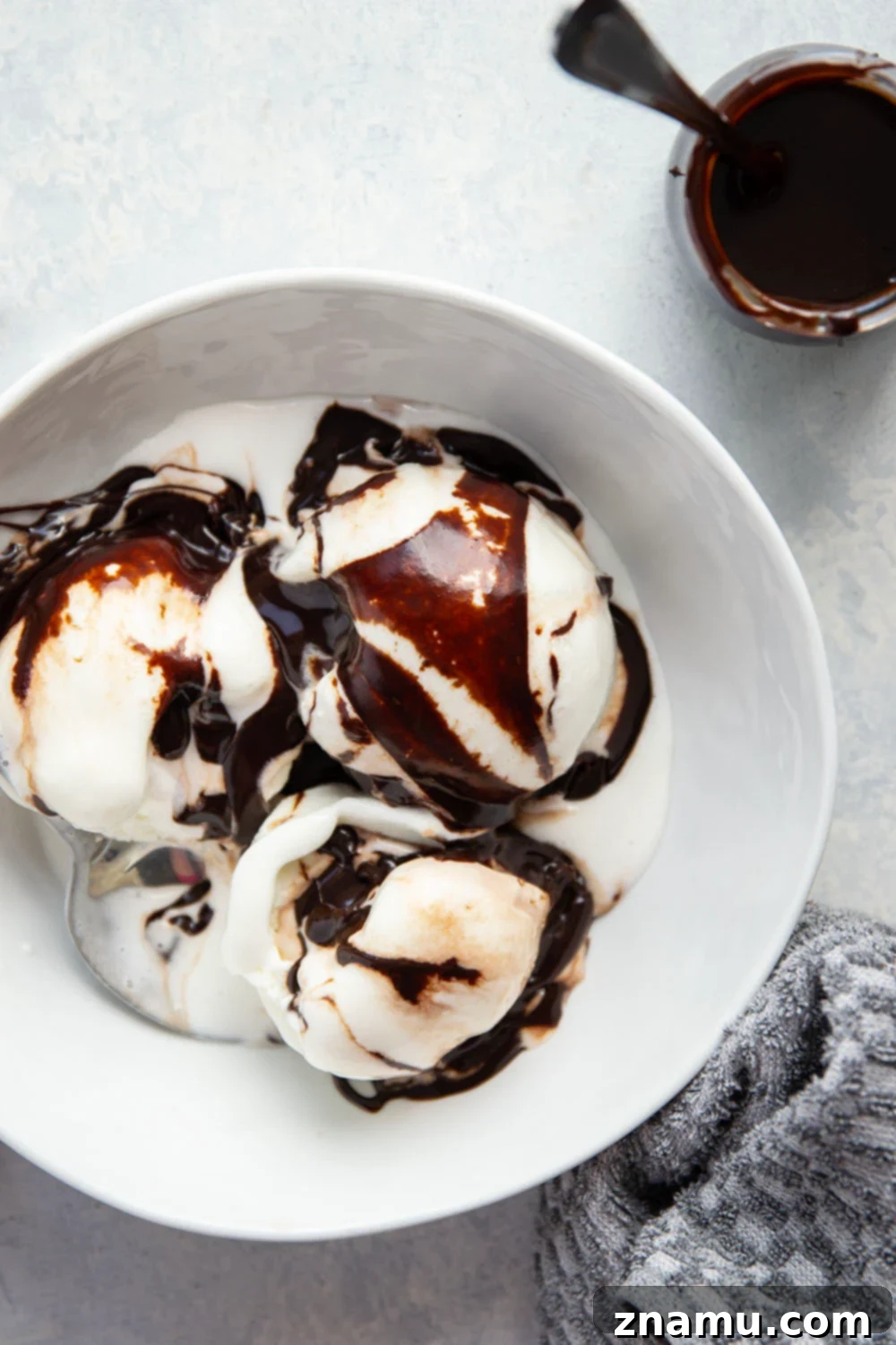 Decadent Homemade Hot Fudge Sauce 4 Close-up of thick hot fudge sauce being drizzled from a spoon, showcasing its perfect texture.