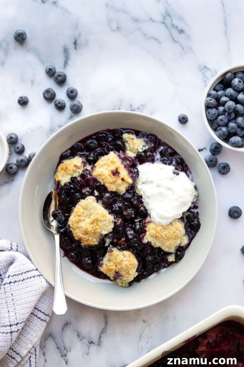 Ultimate Blueberry Cobbler 4 Detailed shot of the blueberry filling and biscuit topping before baking, showcasing the fresh ingredients.