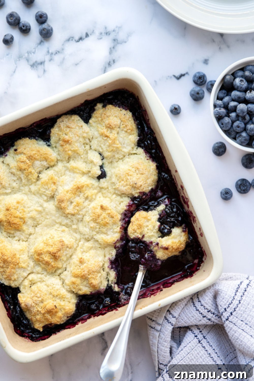 Ultimate Blueberry Cobbler 5 Close-up of baked blueberry cobbler, showcasing the perfectly golden-brown, bubbly fruit filling.
