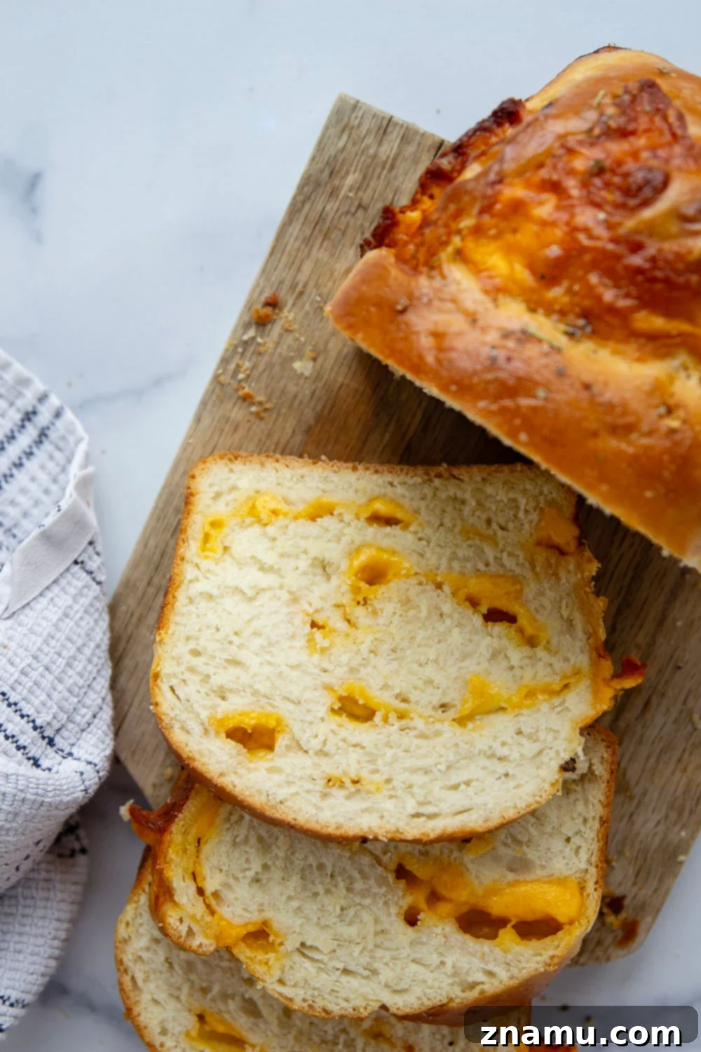 Irresistible Homemade Cheese Bread 4 A close-up of the homemade cheese bread crust, brushed with garlic herb butter, highlighting its golden-brown color and appealing texture.