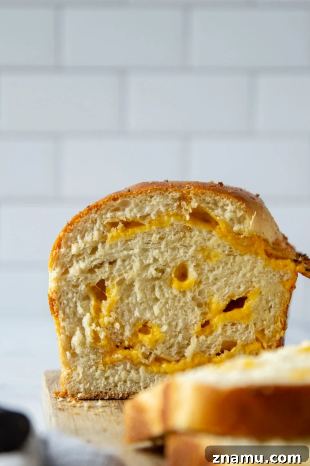 Irresistible Homemade Cheese Bread 7 Several slices of homemade cheese bread arranged on a cutting board, highlighting the soft interior and the melted cheddar.