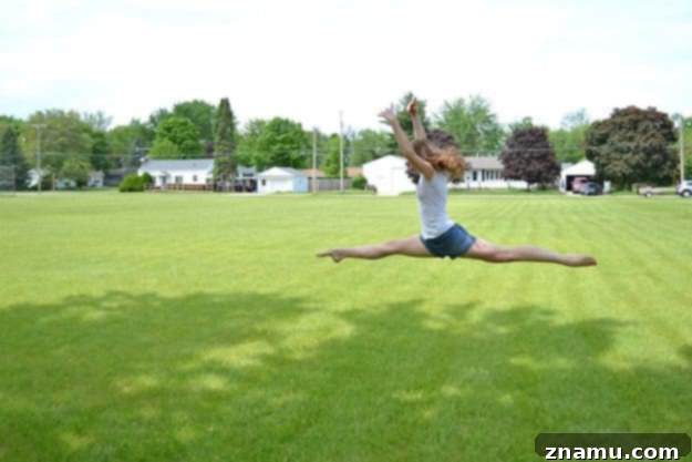 Reliving Summer 2014 6 A person captured mid-air, leaping with joy against a vibrant green summer backdrop, symbolizing happiness.