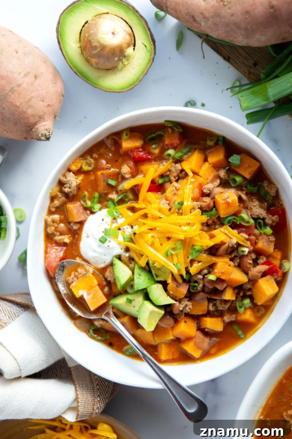 Bowl of Sweet Potato Turkey Chili garnished with fresh cilantro and sour cream