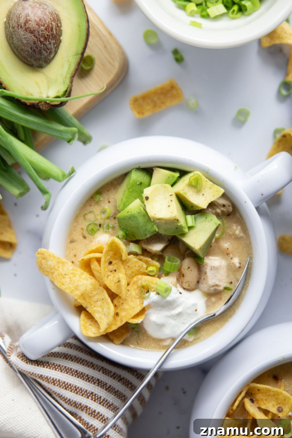 Ultimate White Chicken Chili 4 A vibrant overhead shot of white chicken chili simmering in a large pot, showcasing the various ingredients.