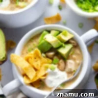 This white chicken chili is the ultimate comfort food! Loaded with lots of tender chicken and beans in a rich broth and piled high with all the toppings.
