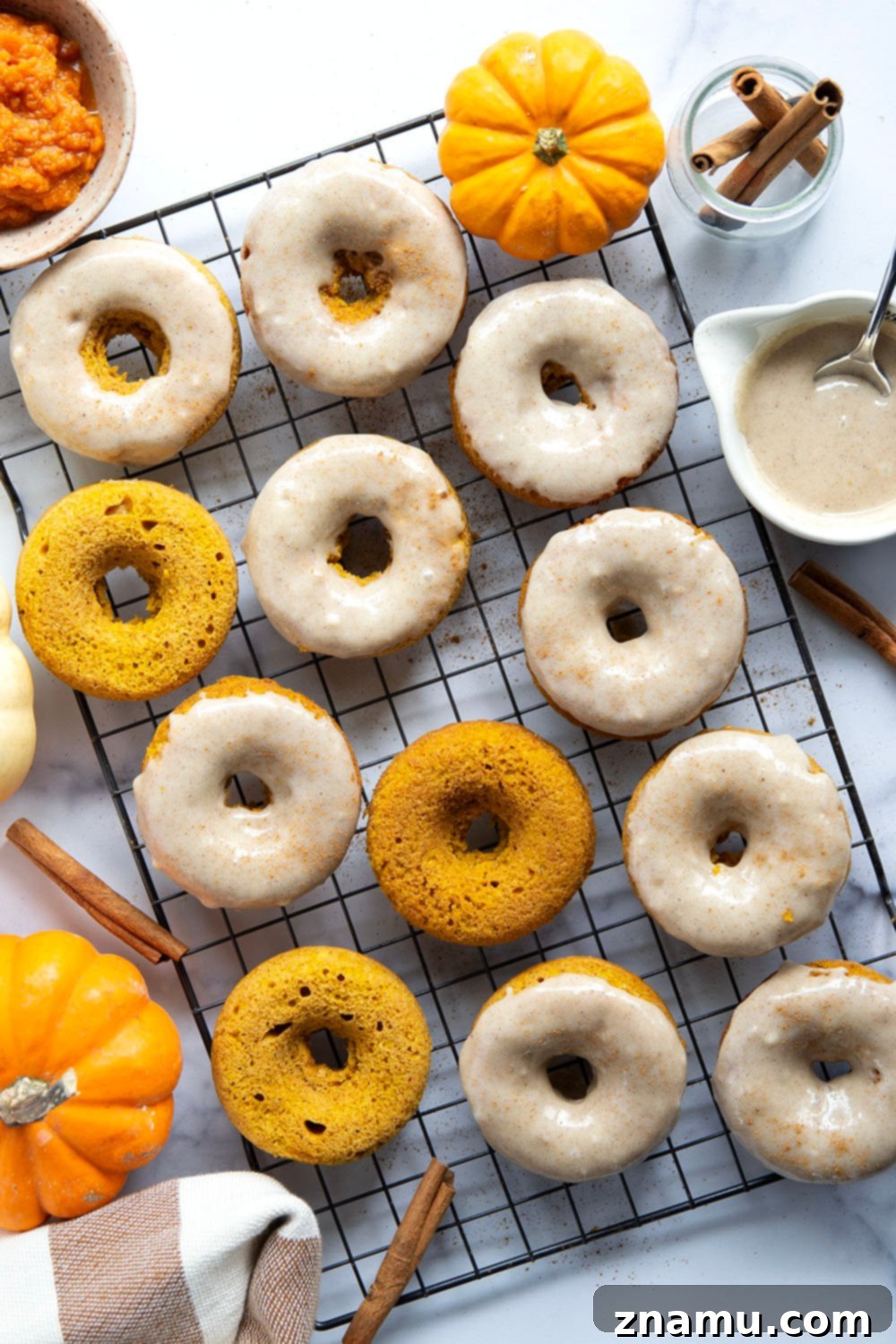 Super soft and fluffy baked pumpkin donuts are dipped in a rich cream cheese glaze and perfect for any fall occasion.