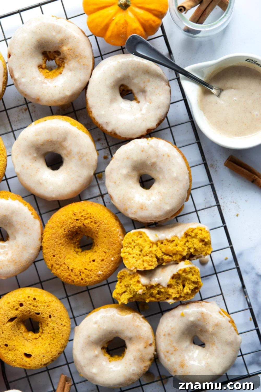 Super soft and fluffy baked pumpkin donuts are dipped in a rich cream cheese glaze and perfect for any fall occasion.
