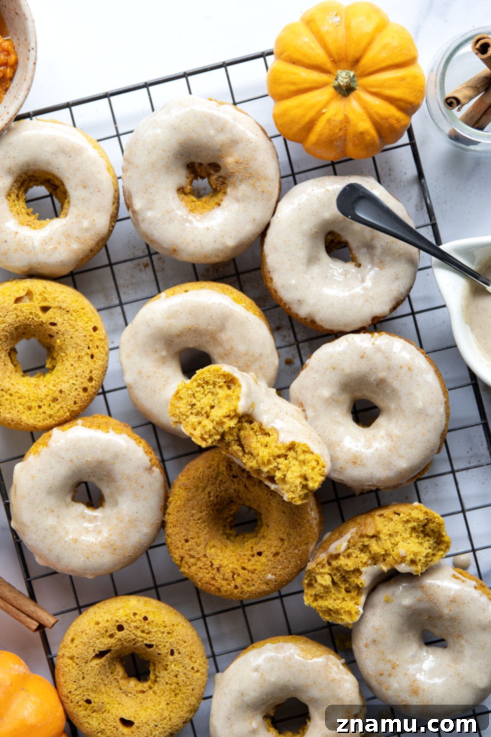 Super soft and fluffy baked pumpkin donuts are dipped in a rich cream cheese glaze and perfect for any fall occasion.