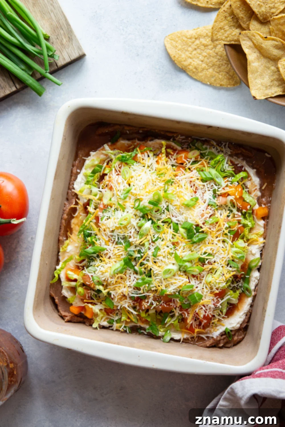 Ultimate Fiesta 7-Layer Dip 3 This 7-layer taco dip features layers upon layers of refried beans, a rich cream cheese filling, and lots of shredded lettuce, cheese, tomatoes, and peppers on top.