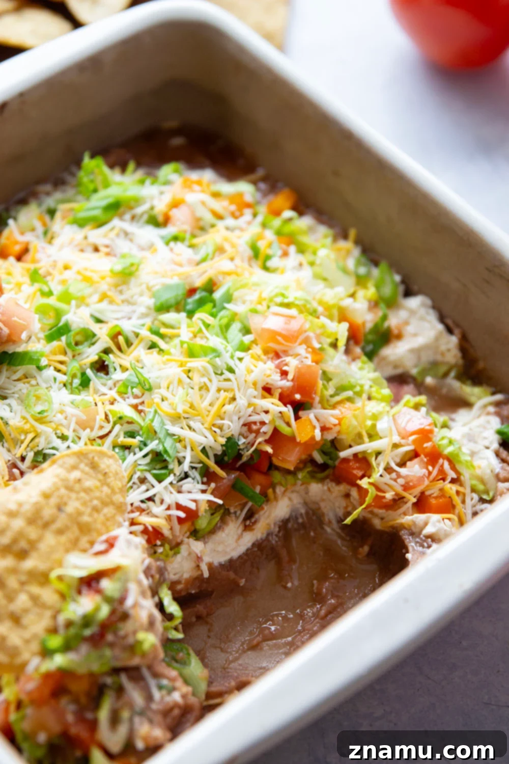 Ultimate Fiesta 7-Layer Dip 4 This 7-layer taco dip features layers upon layers of refried beans, a rich cream cheese filling, and lots of shredded lettuce, cheese, tomatoes, and peppers on top.