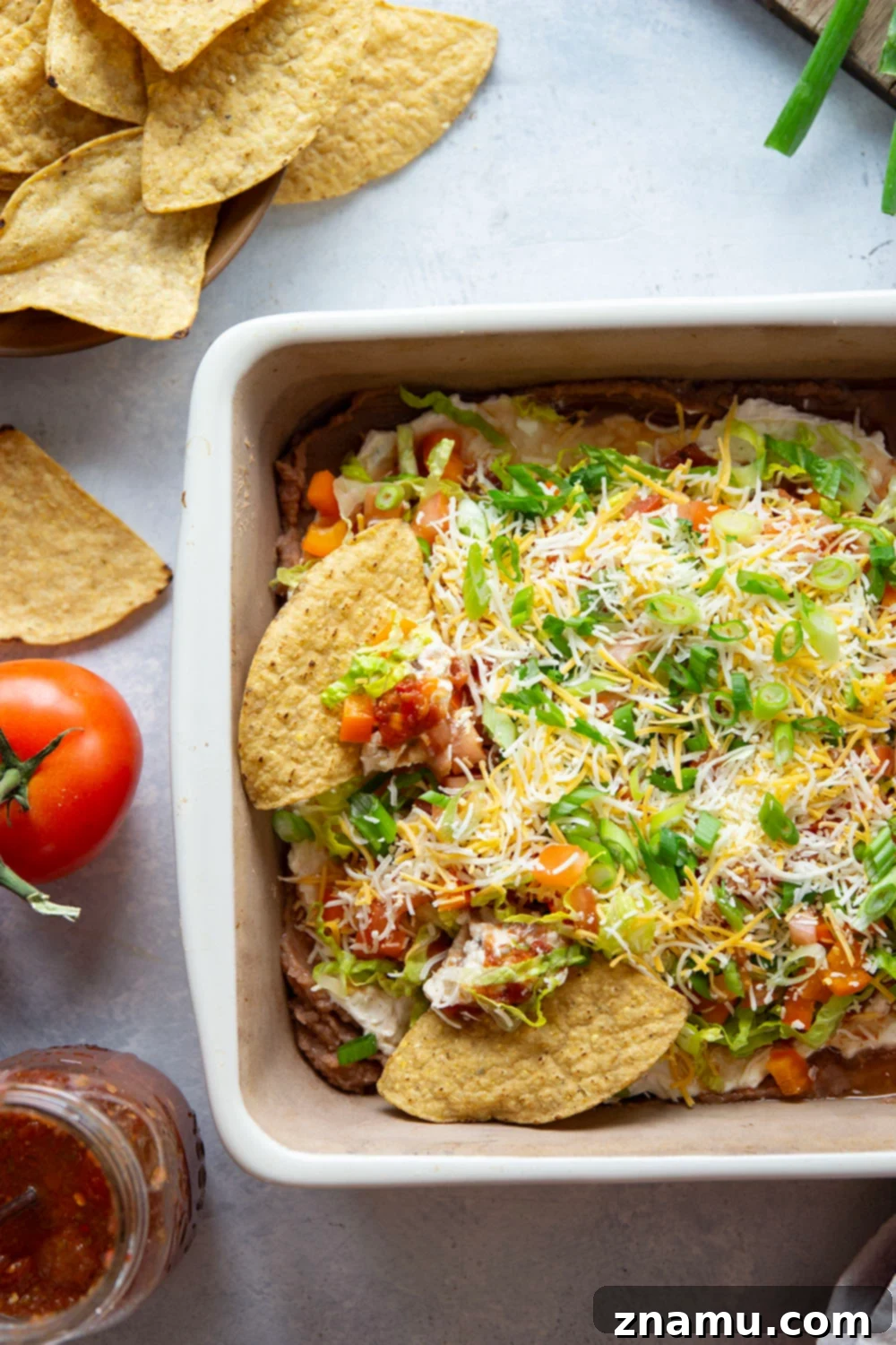 Ultimate Fiesta 7-Layer Dip 5 This 7-layer taco dip features layers upon layers of refried beans, a rich cream cheese filling, and lots of shredded lettuce, cheese, tomatoes, and peppers on top.