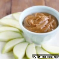 Delicious cinnamon almond butter dip with sliced apples, ready to serve in a small bowl.