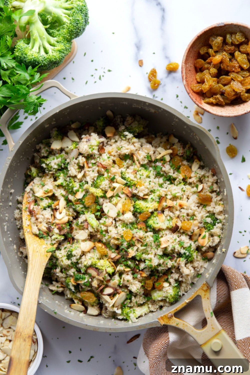 Flavorful Cauliflower Rice Pilaf 2 Fluffy Cauliflower Rice Pilaf with tender broccoli, crunchy almonds, and golden raisins in a serving bowl
