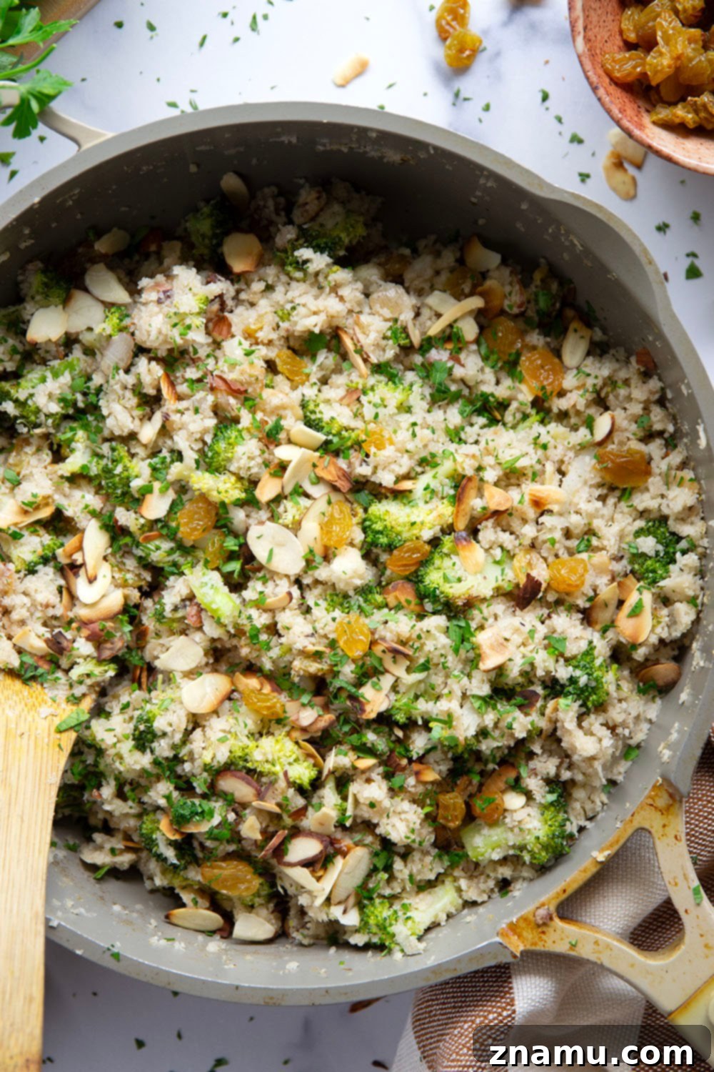 Flavorful Cauliflower Rice Pilaf 3 Close-up of a pan filled with golden Cauliflower Rice Pilaf, showing off its texture and vibrant ingredients, ready to serve.