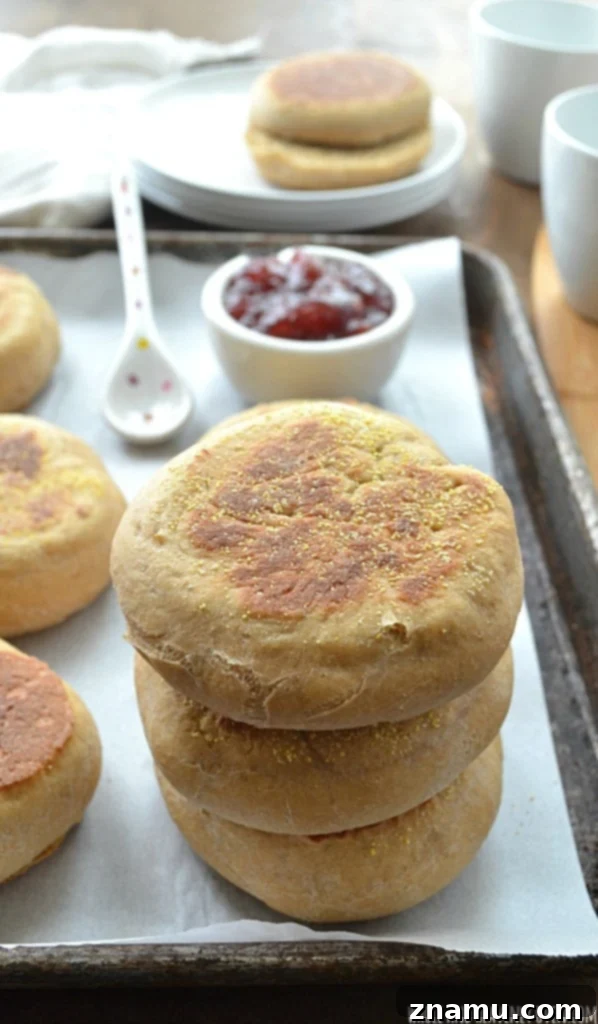 Perfect Homemade English Muffins 9 A plate of two toasted homemade English muffins, buttered and topped with strawberry jam