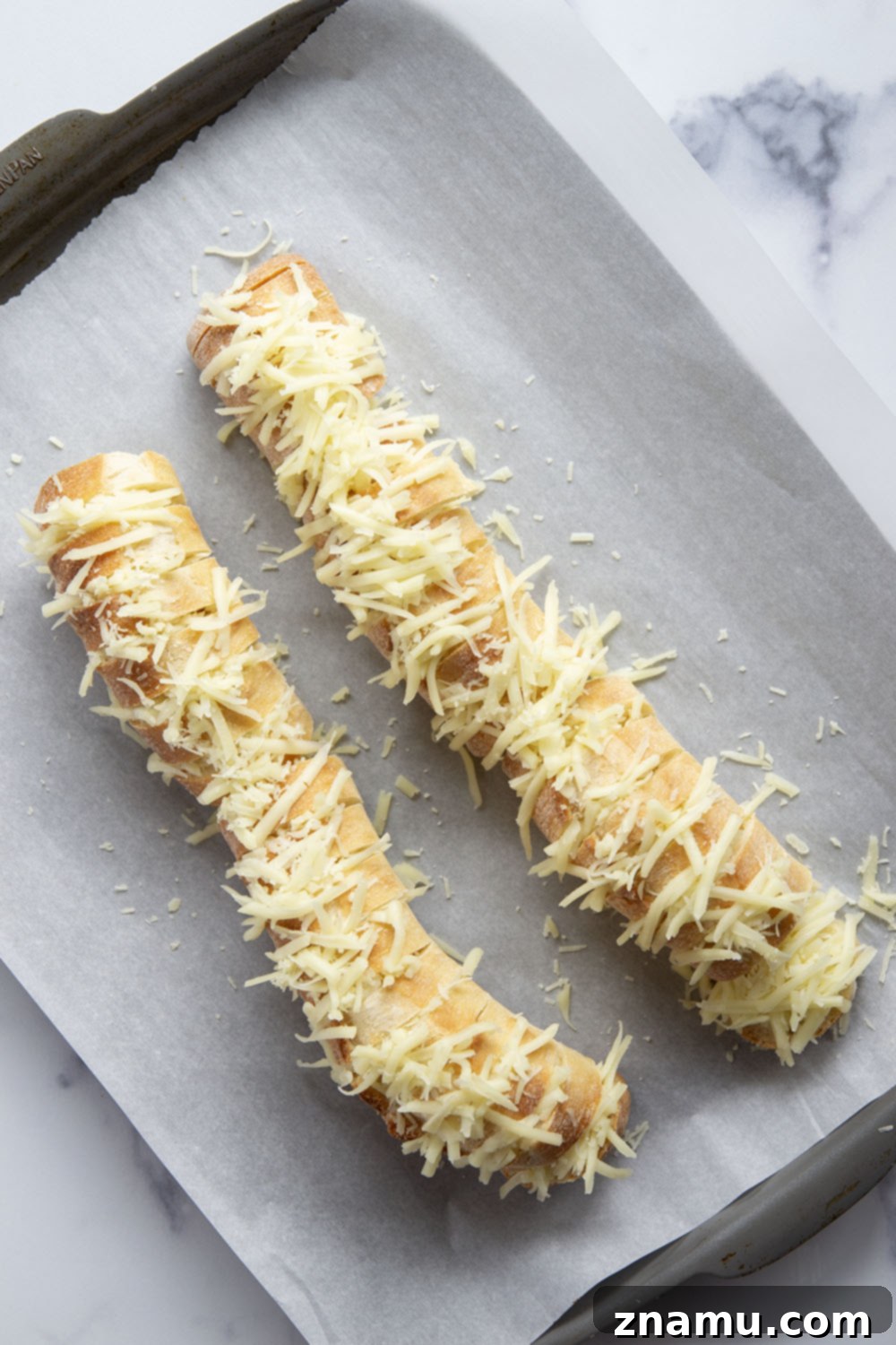 Cheesy Garlic Pull-Apart Bread 3 This cheesy garlic hasselback bread is baked with gooey mozzarella and Parmesan between slices and brushed in a garlicky herb butter.