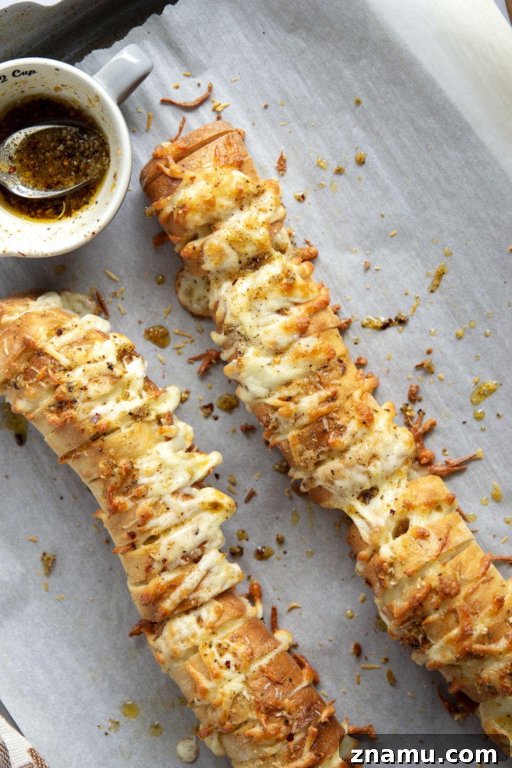 Cheesy Garlic Pull-Apart Bread 4 This cheesy garlic hasselback bread is baked with gooey mozzarella and Parmesan between slices and brushed in a garlicky herb butter.