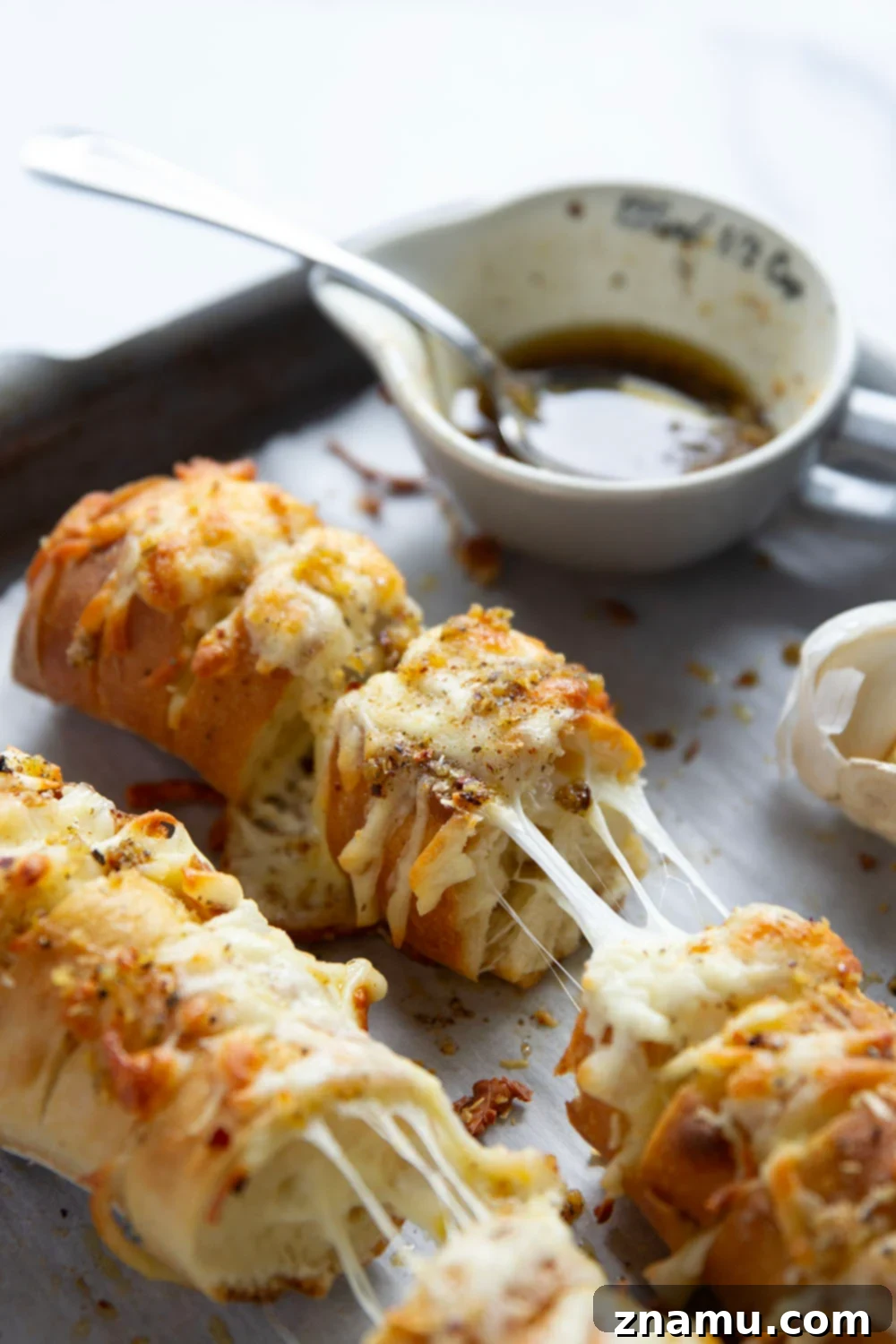 Cheesy Garlic Pull-Apart Bread 5 This cheesy garlic hasselback bread is baked with gooey mozzarella and Parmesan between slices and brushed in a garlicky herb butter.