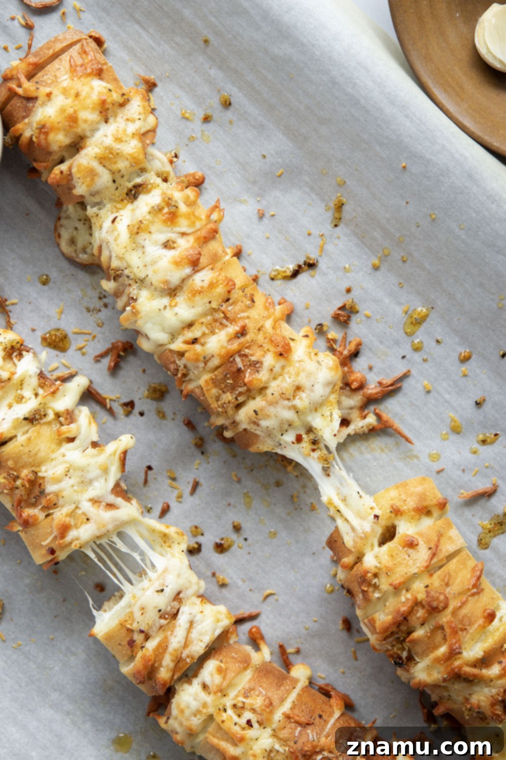 Cheesy Garlic Pull-Apart Bread 6 This cheesy garlic hasselback bread is baked with gooey mozzarella and Parmesan between slices and brushed in a garlicky herb butter.
