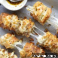Cheesy Garlic Pull-Apart Bread 8 This cheesy garlic hasselback bread is baked with gooey mozzarella and Parmesan between slices and brushed in a garlicky herb butter.