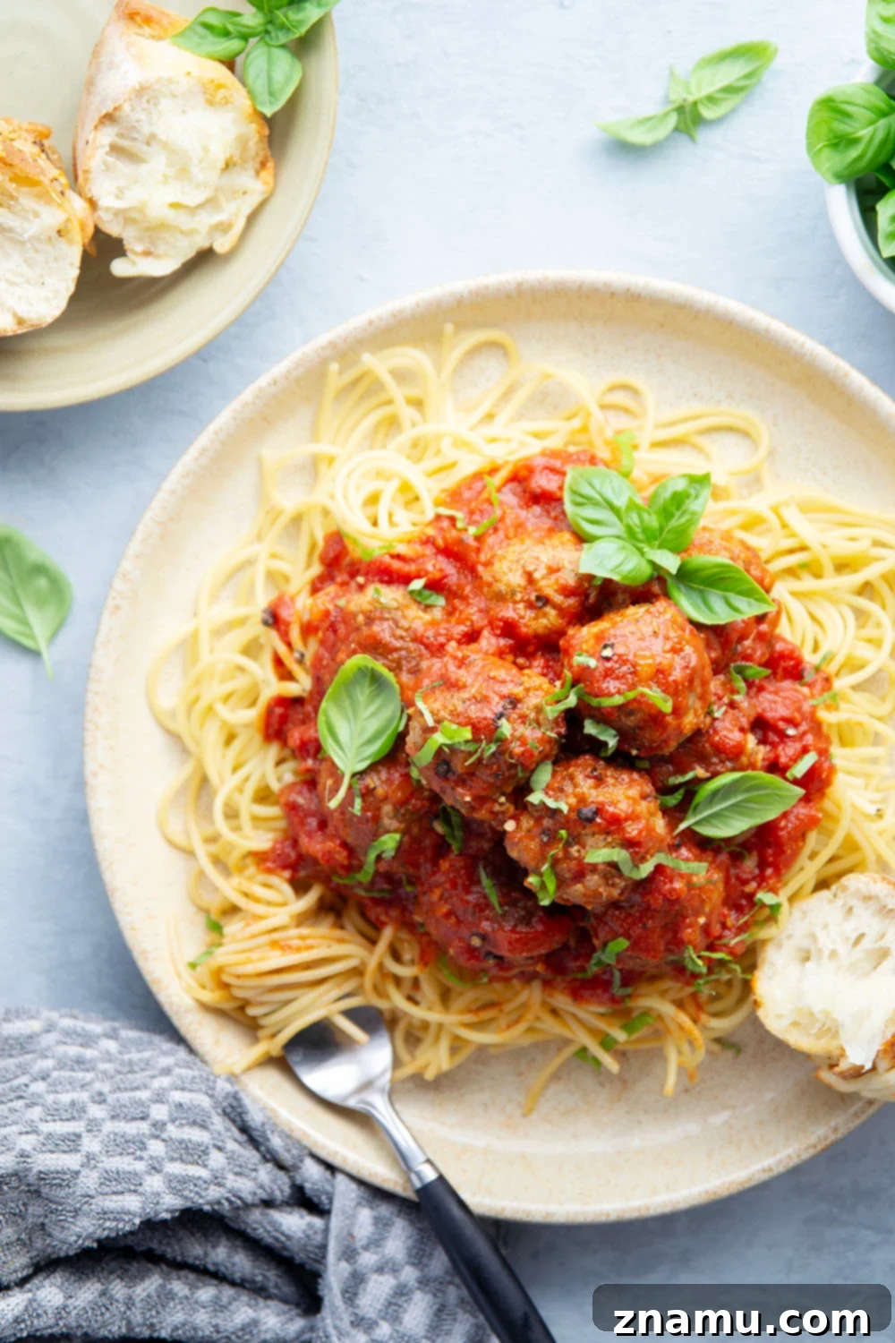Simply Delicious Spaghetti and Meatballs 4 Serving of easy spaghetti and meatballs in a bowl, garnished with basil