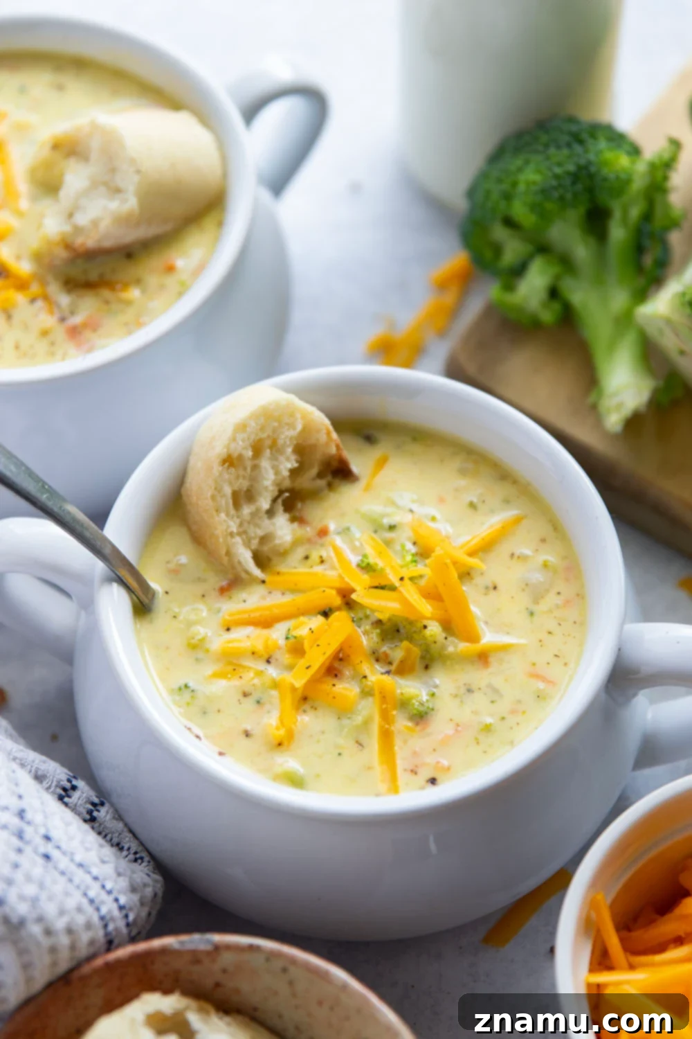 Quick and Creamy Broccoli Cheddar Soup 6 A bowl of creamy broccoli cheddar soup with a piece of crusty bread dipped in, highlighting the rich texture.