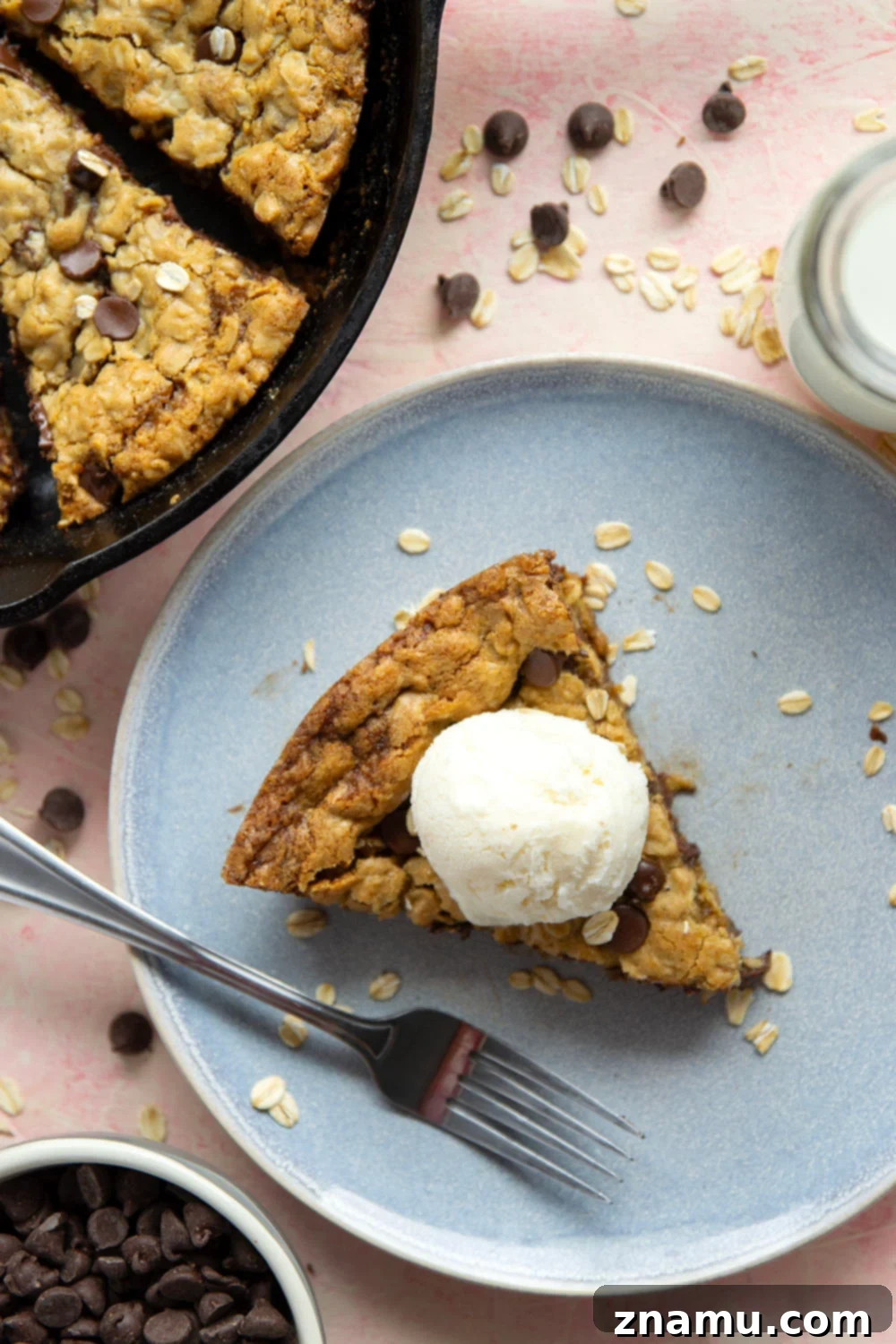 Warm Skillet Chocolate Oat Treat 5 A cast iron skillet holding a freshly baked oatmeal cookie, with a spoon ready to scoop. Emphasizes the ease of this skillet dessert.
