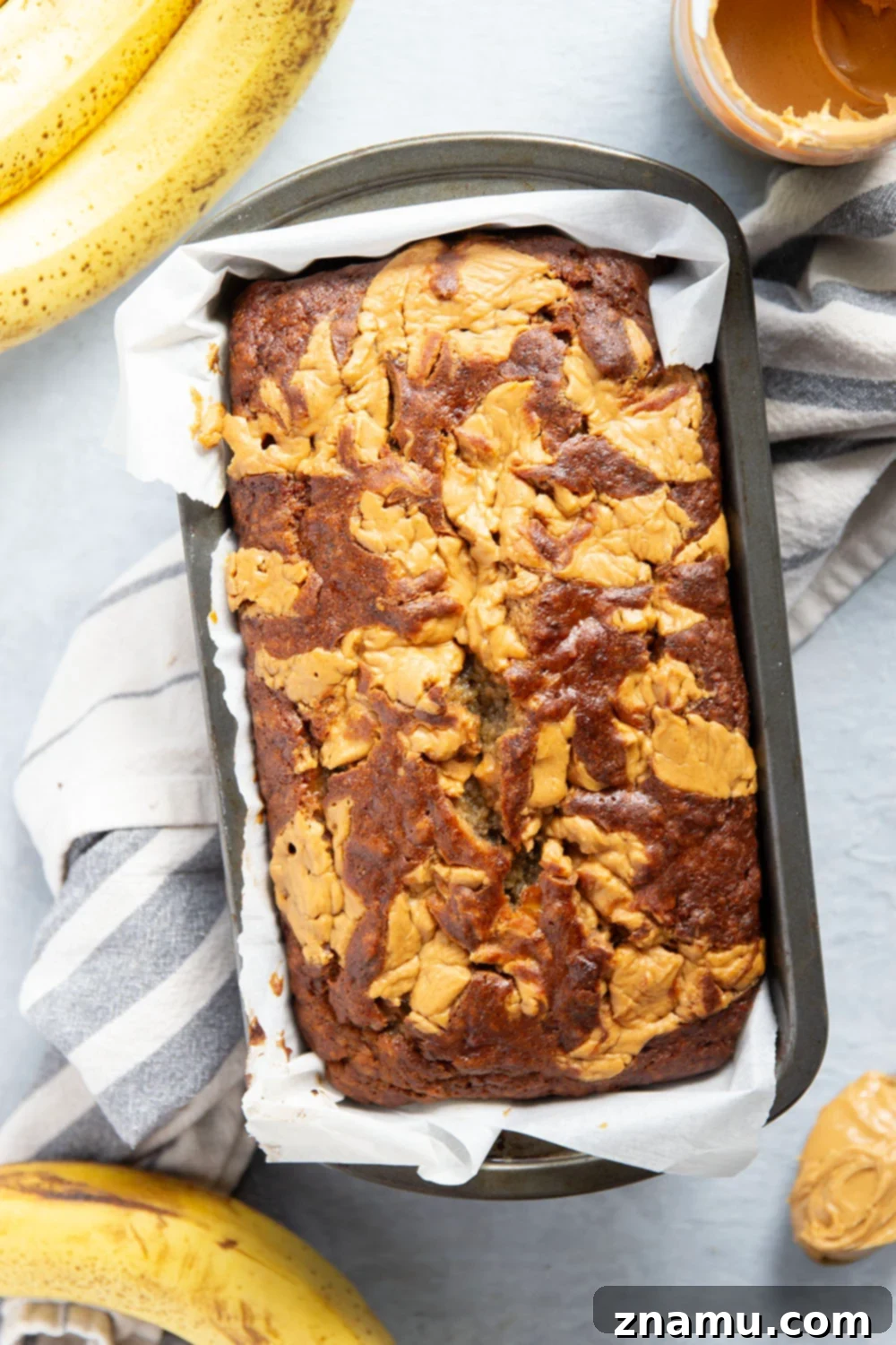 Nutty Banana Bread Bliss 3 A slice of moist peanut butter banana bread, revealing soft texture and delightful peanut butter swirls, ready to be savored.