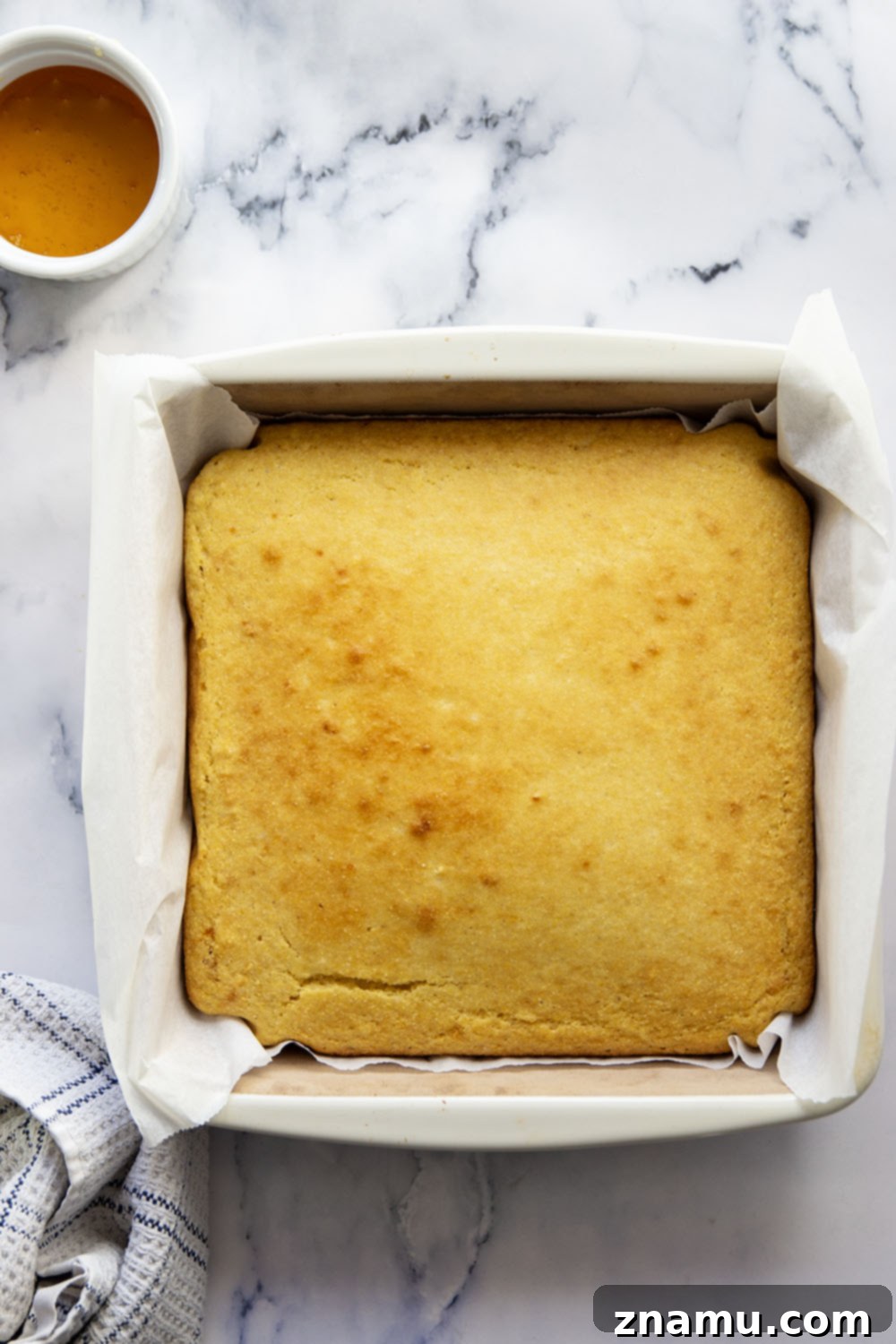 Golden Buttermilk Cornbread 3 Close-up of freshly baked buttermilk cornbread squares in a baking dish, ready to be served.