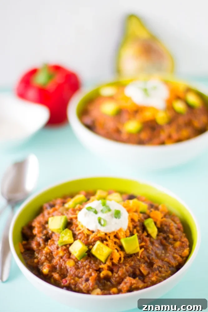 Plant-Powered Slow Cooker Quinoa and Black Bean Chili 3 Close-up of a bowl of Vegan Crockpot Quinoa and Black Bean Chili, garnished with fresh cilantro and a dollop of vegan sour cream, highlighting the rich texture.