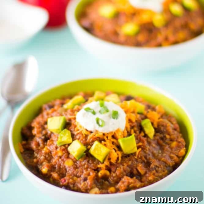 Plant-Powered Slow Cooker Quinoa and Black Bean Chili 6 A beautifully presented bowl of Vegan Crockpot Quinoa and Black Bean Chili, topped with creamy cashew sour cream, fresh cilantro, and avocado slices.