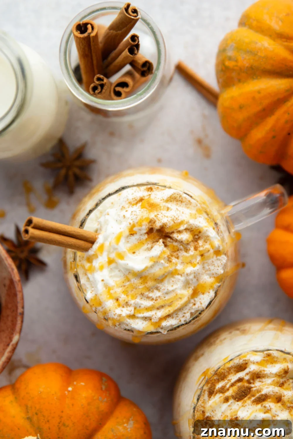 Golden Pumpkin Swirl Latte 4 A hand holding a mug of Caramel Pumpkin Spice Latte, showcasing the inviting warmth and rich color of the beverage.
