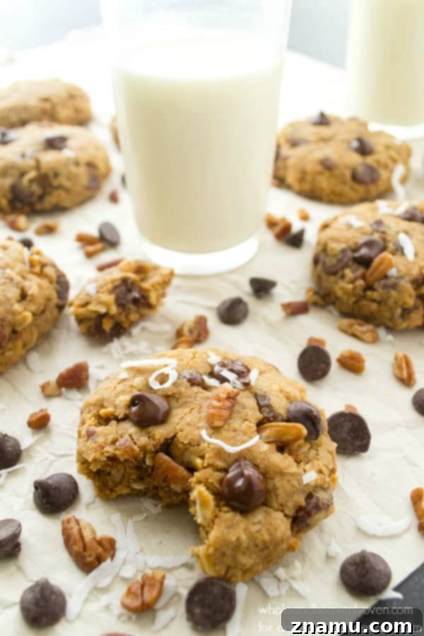 Ultimate Everything Cookies 6 Soft-Baked Kitchen Sink Cookies being dipped in a glass of milk
