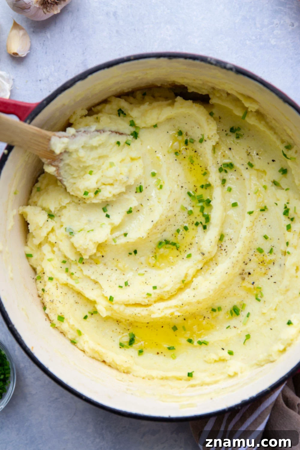 Velvety Garlic Mashed Potatoes 6 Serving bowl filled with creamy garlic mashed potatoes garnished with fresh chives.