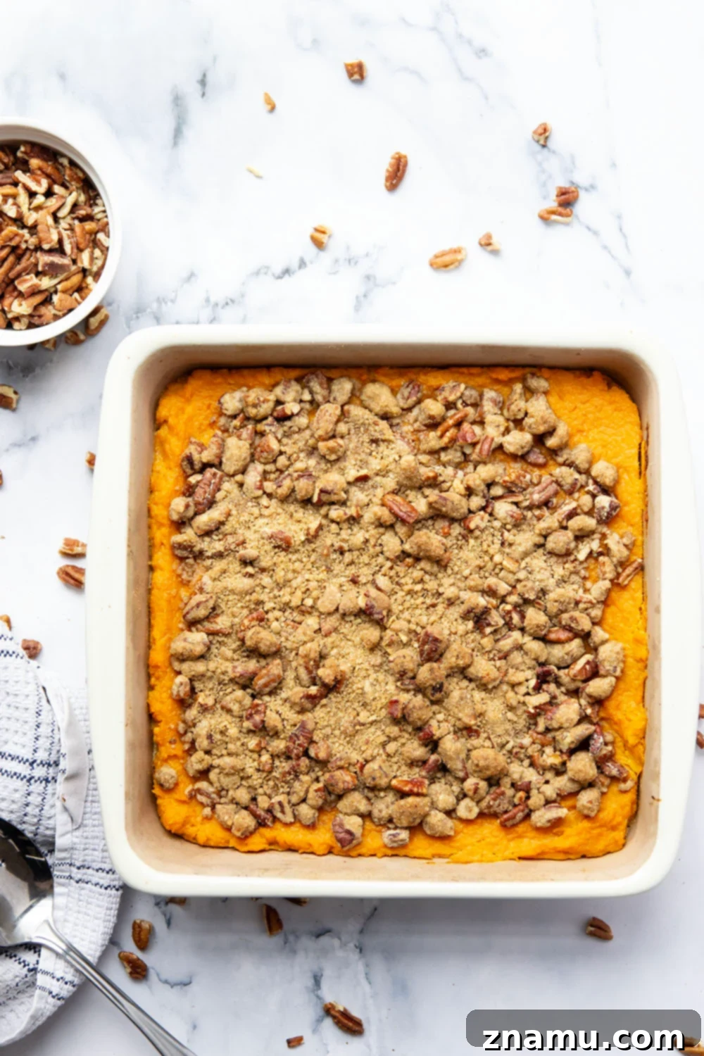 Velvety Sweet Potato Bake with Crunchy Pecan Topping 3 Close-up of a sweet potato casserole showing the rich, creamy mashed potatoes under a generous layer of crunchy pecan streusel.