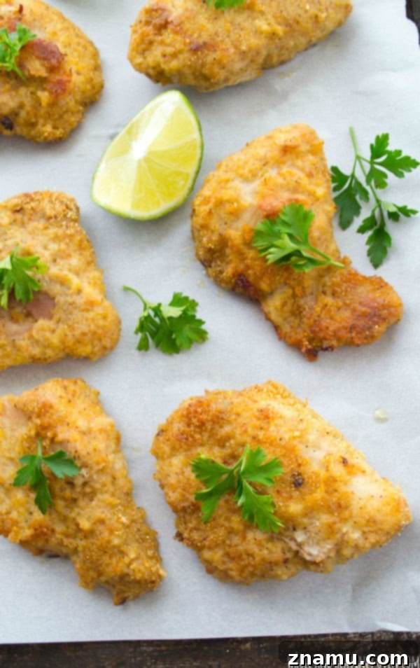 Golden Crispy Oven Chicken Tenders 3 Freshly baked crispy chicken tenders cooling on a rack, showcasing their golden crust.