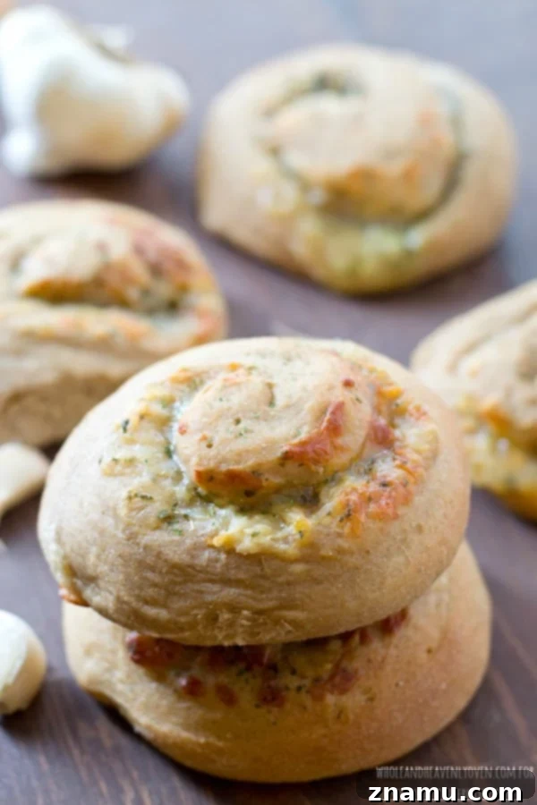 Irresistible Garlic Cheese Spirals 6 A generous serving of freshly baked cheesy garlic spiral rolls on a plate, steamy and inviting, showcasing their fluffy texture and golden crust.