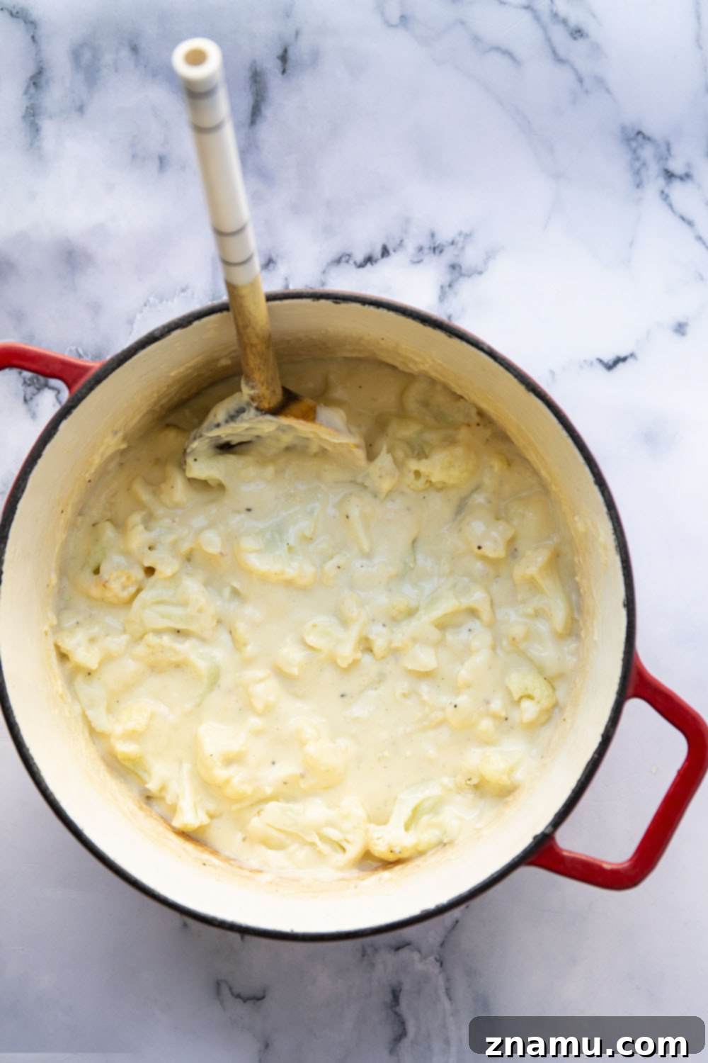 Creamy Cauliflower Mac 3 Overhead view of a baking dish filled with cauliflower mac and cheese, ready for serving.