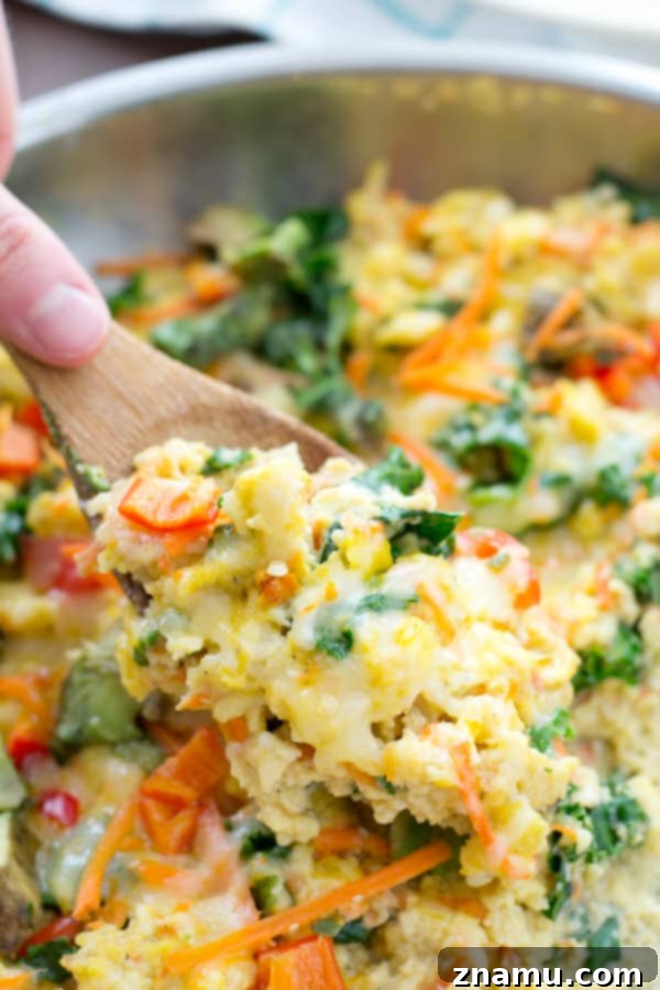 Serving of Rainbow Veggie Scrambled Eggs with crispy bacon on the side