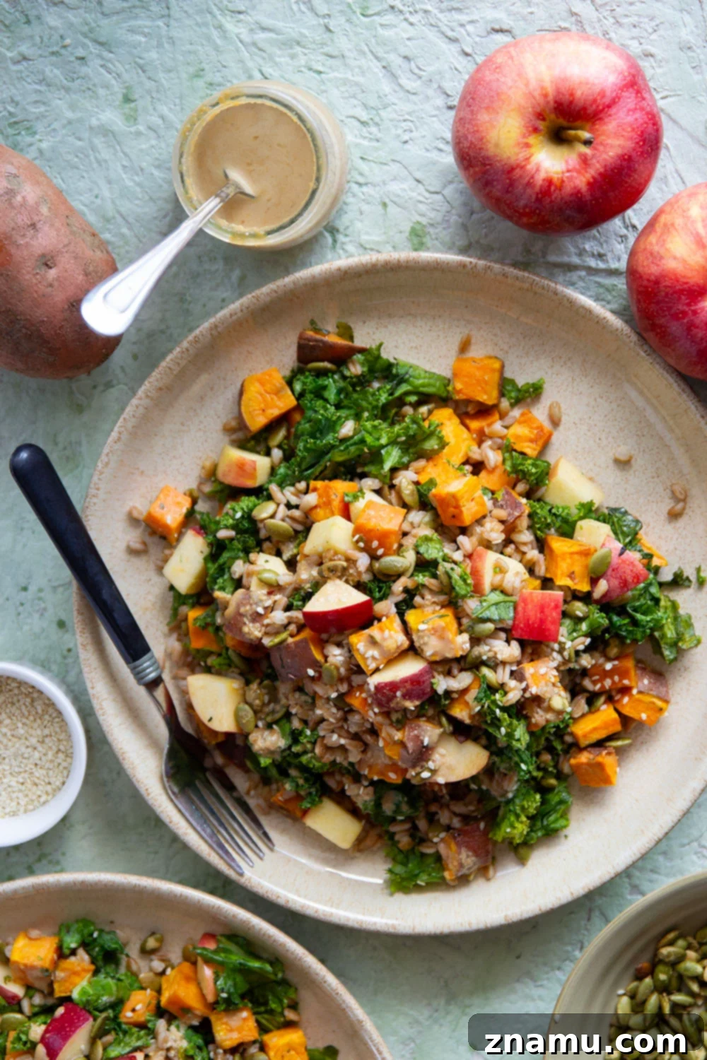 Golden Roasted Sweet Potato Farro Salad with Savory Sesame Drizzle 5 A serving of Roasted Sweet Potato Farro Salad in a rustic bowl, highlighting the perfectly roasted sweet potatoes and individual farro grains, garnished with fresh herbs.