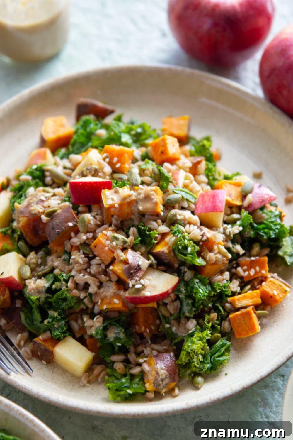 Golden Roasted Sweet Potato Farro Salad with Savory Sesame Drizzle 6 A beautifully presented bowl of Roasted Sweet Potato Farro Salad, featuring a generous amount of savory sesame dressing drizzled over the top, ready for serving.