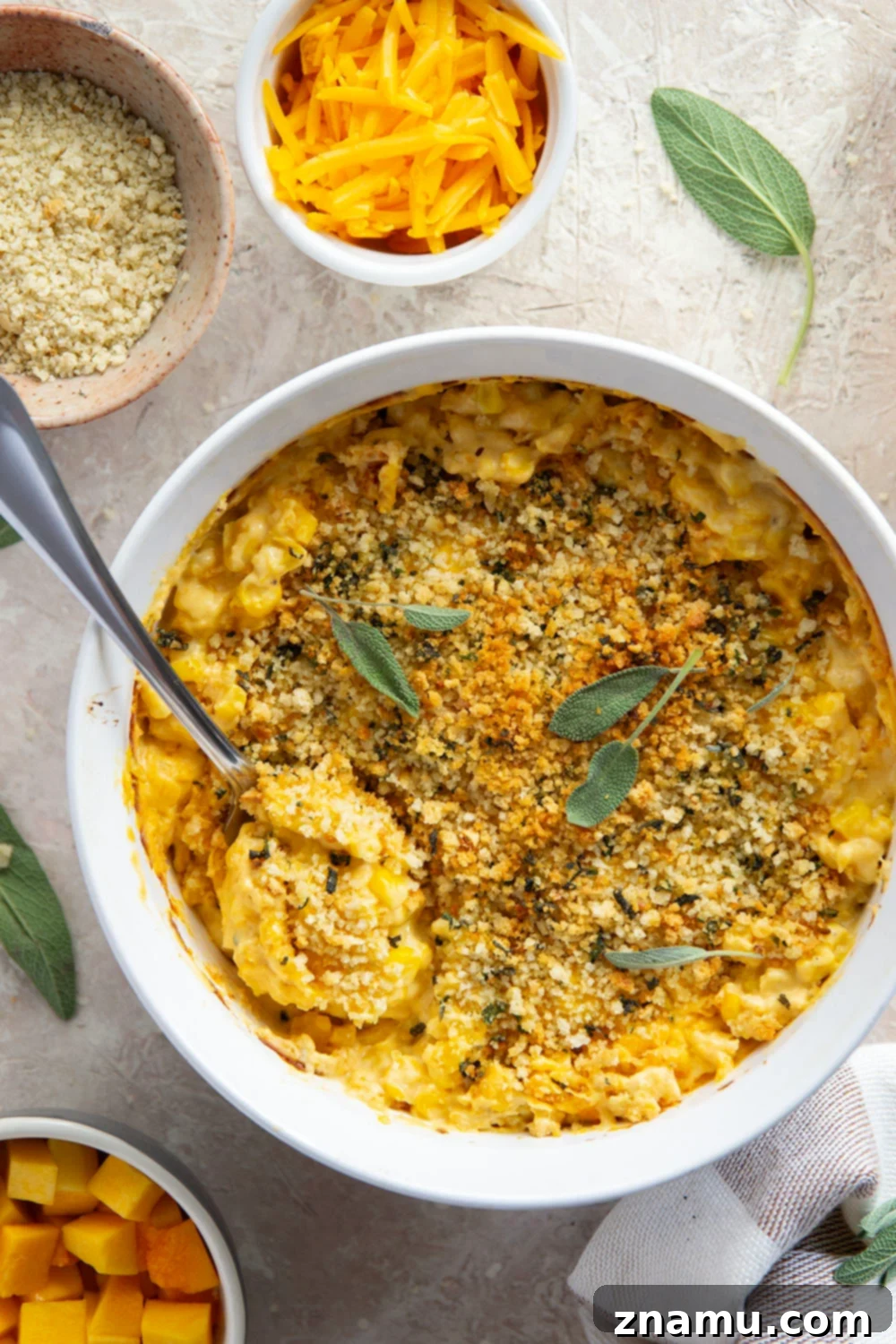Golden Butternut Creamed Corn 4 A close-up view highlighting the rich, creamy texture of butternut squash creamed corn with visible corn kernels and melted cheese, prior to baking.