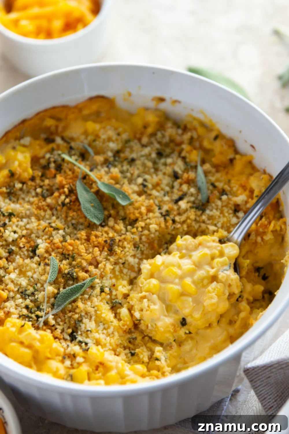 Golden Butternut Creamed Corn 6 The baked Butternut Squash Creamed Corn, garnished with fresh sage, showcasing its golden crispy topping and creamy interior.