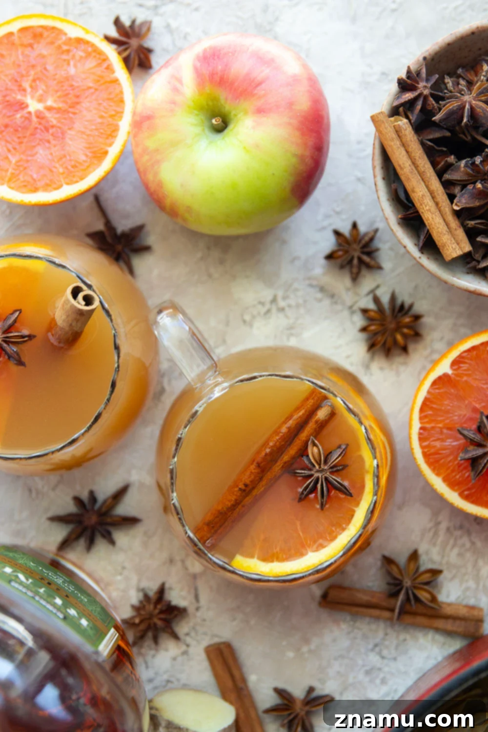 Chai-Spiced Apple Cider 2 Chai Mulled Apple Cider simmering on the stovetop, garnished with orange slices and spices.